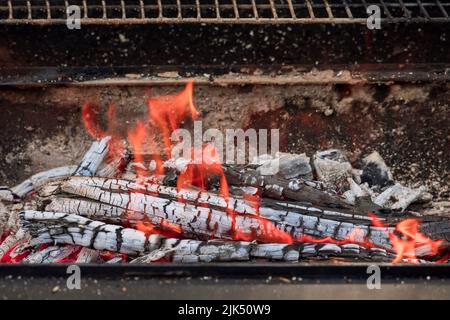 In preparation of the fire for grilling, you will work in flames from a burning charcoal log and make fire on a bonfire before cooking. Stock Photo