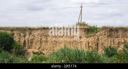 The cut of the earth, the collapse of the slope. Nests of shorebird swallows in a sand pit. Burrows in the ground. Stock Photo