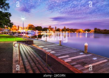 WOoden pavement boardwalk along riverfront on Wallis lake in Forster town of Australia at sunset. Stock Photo