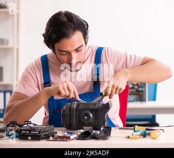 The young male contractor repairing computer Stock Photo
