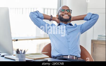 I did it all in a day. a businessman looking relaxed while sitting in his office. Stock Photo