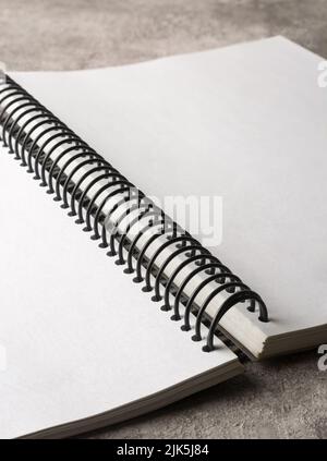 opened book with wire spiral binding on table top, blank and no line white pages, selective focus Stock Photo