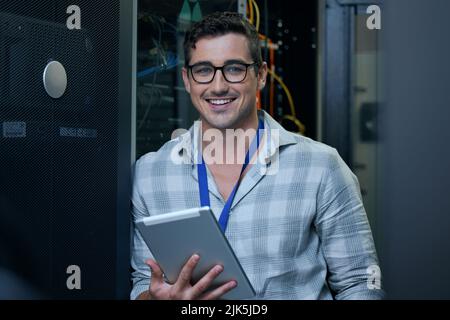 Coding is what I do. Cropped portrait of a handsome young male programmer working on a tablet in a server room. Stock Photo