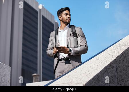 Stay focused on the future. a young businessman using a phone in the city. Stock Photo