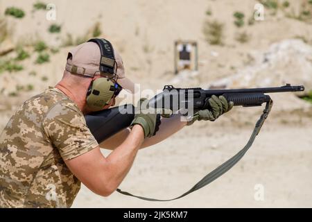 Ukrainian civilian takes part in a shooting training to learn military ...