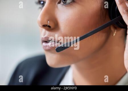 Im always ready for the next call. an attractive young businesswoman sitting alone in her office and wearing a headset. Stock Photo