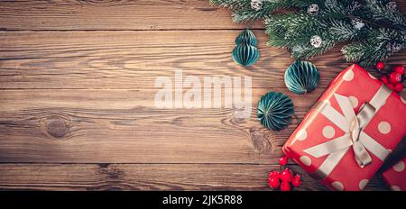 Christmas gift, Christmas tree branch with decorations on wood background Stock Photo