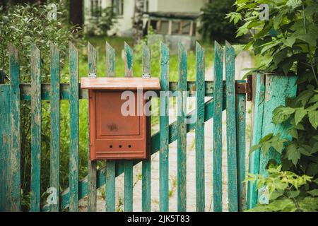 Old vintage brown mailbox on the fence of a private house Stock Photo