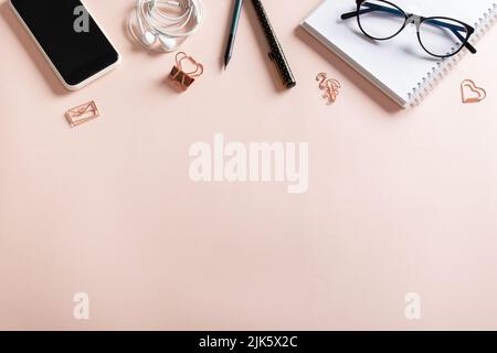 Smartphone, clean blank notepad, headphones, glasses, pen, paper clips, pencil on a light background. Make room for the text. Blogging in the workplac Stock Photo