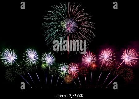 Festive beautiful colorful fireworks display on the sea beach, Amazing holiday fireworks party or any celebration event in the dark sky Stock Photo