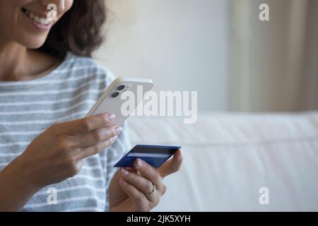 Happy smartphone user woman holding credit card Stock Photo