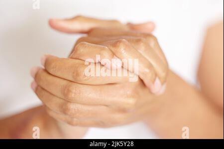 This moisturiser keeps my hands soft and smelling good. an unrecognisable woman moisturising her hands. Stock Photo