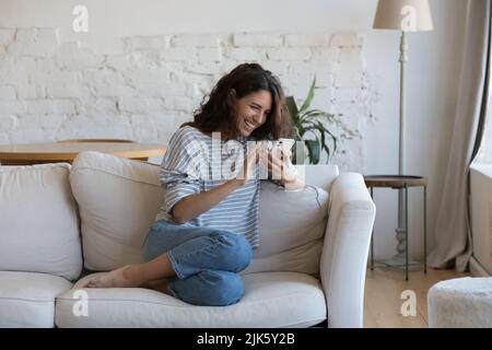 Excited happy young adult woman reading message on mobile phone Stock Photo