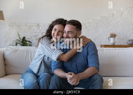 Happy joyful married couple in love sitting on couch Stock Photo