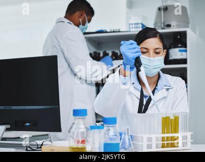 Playing around with chemistry. two young researchers working in a laboratory. Stock Photo