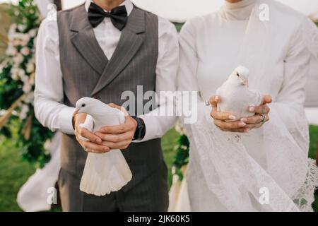 Wedding pigeons. White doves in the hands of the newlyweds. Stock Photo