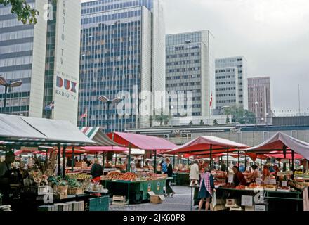 A view of the Hötorget buildings (Hötorgshusen or Hötorgsskraporna) in the central Norrmalm district, Stockholm, Sweden in 1970. In the foreground is the Hötorget torghandel (market) outside the Konserthuset (Consert House). The Hötorget buildings are five modernist high-rise office blocks. The nearest block carries a giant advertising logo for Dux TVs and radios. Norrmalm is at centre of Stockholm. This image is from an amateur 35mm colour transparency – a vintage 1970s photograph. Stock Photo