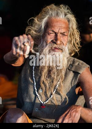 Indian holy man Amar Bharati Urdhavaahu, who has kept his arm raised for over 40 years in honour of Hindu God Shiva, at Kumbh Mela Festival in India. Stock Photo