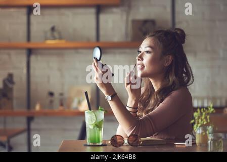 Beautiful Vietnamese young woman applying lip gloss Stock Photo