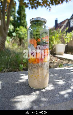 Three glass jars with layering various vegan salads for healthy lunch. The concept of fitness and vegetarian food. Stock Photo