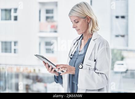 Going the paperless route of in patient care. a mature doctor using a digital tablet at work. Stock Photo
