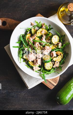 fresh salad with arugula, baked zucchini and tuna. the concept of healthy and nutritious food. Stock Photo