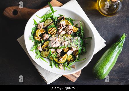 fresh salad with arugula, baked zucchini and tuna. the concept of healthy and nutritious food. Stock Photo