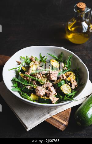 fresh salad with arugula, baked zucchini and tuna. the concept of healthy and nutritious food. Stock Photo