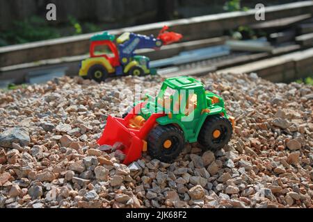 Toy tractors on a pile of rubble, kids game Stock Photo
