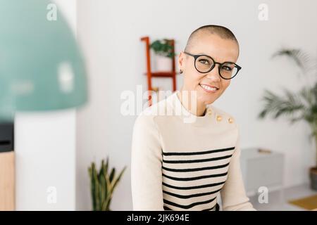 Successful mid adult business woman sitting on desk at home office Stock Photo