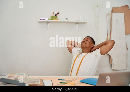 Happy young tailor after working day in atelier Stock Photo