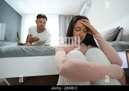 Unpleasant quarrel between man and woman in family bedroom Stock Photo