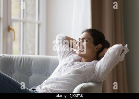Cheerful pretty young Indian woman enjoying leisure, lazy break Stock Photo