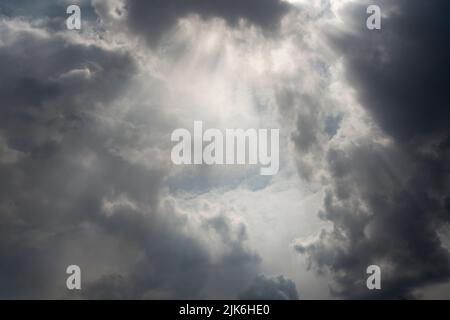 Storm clouds gathering with rays of the sun breaking through Stock Photo