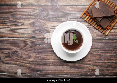 flat composition of dark chocolate cream in a coffee cup on table  Stock Photo