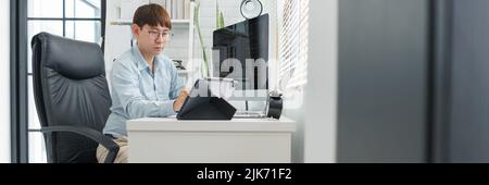 Software development concept, Male programmer point data on tablet to checking website programming. Stock Photo