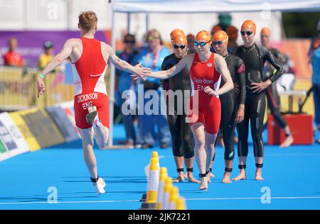 England's Sam Dickinson hands over to Georgia Taylor-Brown on their way to gold in the mixed relay Triathlon on day three of the 2022 Commonwealth Games in Birmingham. Picture date: Sunday July 31, 2022. Stock Photo