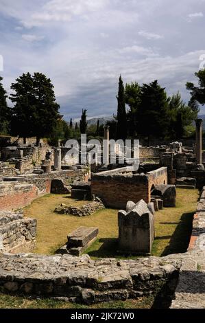 Foundations of 400s AD basilica amid plundered sarcophagi, some bearing Christian symbols, scattered in the Necropolis of Manastirine outside the walls of the ancient Illyrian, Greek and Roman city of Salona, near Split, Dalmatia, Croatia.  Many early Christians martyred by Roman Emperor Diocletian lie buried here. Stock Photo