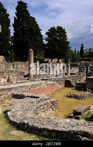 Foundations of the curved apse of a 400s AD basilica amid plundered sarcophagi, some bearing Christian symbols, scattered in the Necropolis of Manastirine outside the walls of the ancient Illyrian, Greek and Roman city of Salona, near Split, Dalmatia, Croatia.  Many early Christians martyred by Roman Emperor Diocletian lie buried here. Stock Photo