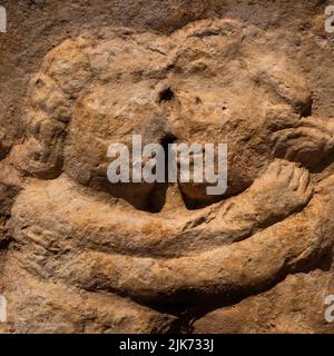 Embracing putti or cherubs, sculpted in relief on a plundered Roman stone sarcophagus in the Necropolis of Manastirine, outside the walls of the Greek and Roman city of Salona, at Solin near Split, Dalmatia, Croatia.  Images from Greco-Roman mythology are mixed here with later Christian symbols commemorating martyrs executed by Roman Emperor Diocletian. Stock Photo