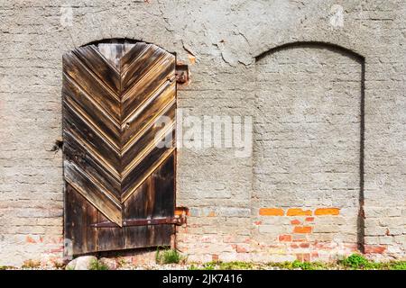 an old wooden door in a masonry and red brick wall Stock Photo