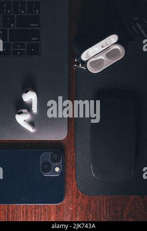 Overhead shot of dark workplacewith a laptop, smartphone and wireless headphones. Stock Photo