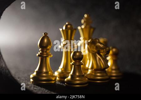 golden chess pieces close-up on a gray background Stock Photo