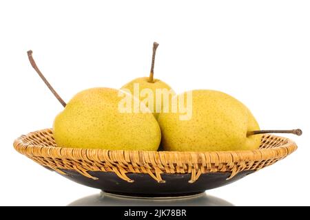 Three organic bright yellow pears on a ceramic plate, close-up, isolated on a white background. Stock Photo