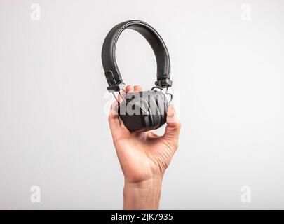 Black modern wireless headphones in male hand close up. High quality photo Stock Photo