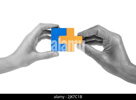 Man and woman hands with two matching puzzle pieces isolated on white background. Partnership, connection concept. Mutual understanding, support in relations. High quality photo Stock Photo