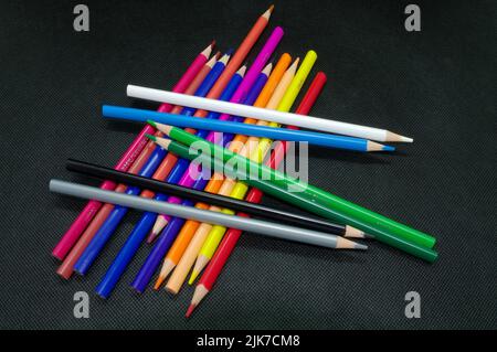 Painting and drawing: Various colored pencils against black background, crisscrossed Stock Photo