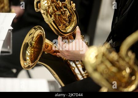 A closeup of the hands of a musician playing a baritone saxophone. Stock Photo