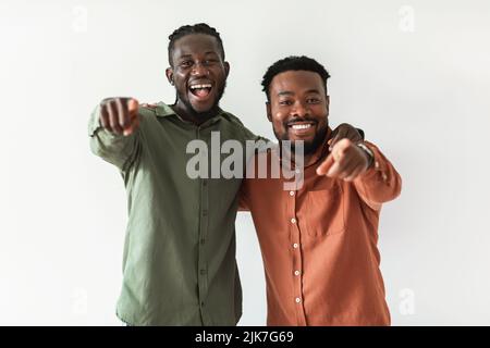 Two Happy African Guys Pointing Fingers At Camera, White Background Stock Photo