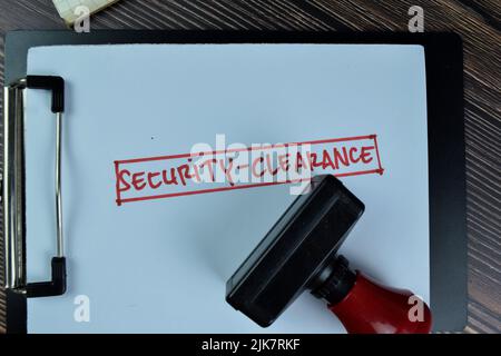 Concept of Security-Clearance write on a paperwork isolated on Wooden Table. Stock Photo